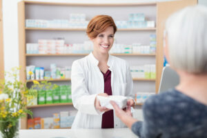 pharmacist handing a woman her perscription